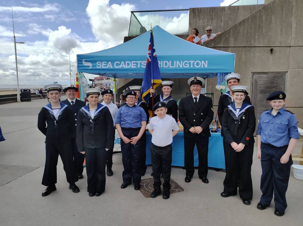 Photograph of some of Bridlington's Sea Cadets taken on Armed Forces Day in front of their fundraising stall.