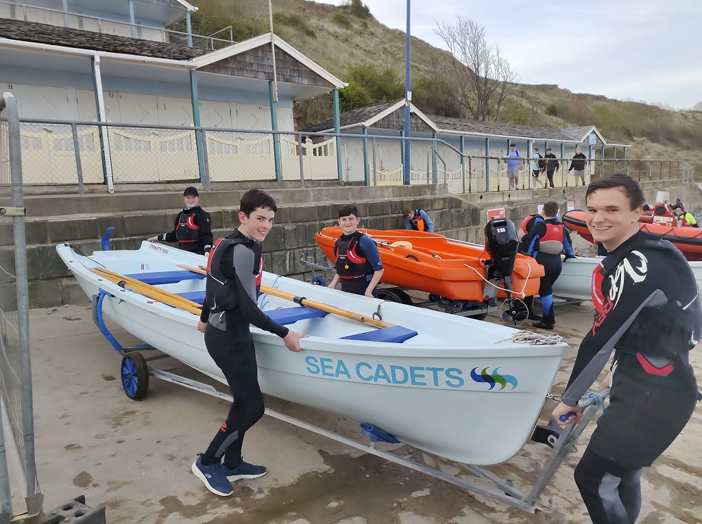 rowing team walking with Trinity rowing boat on trailer