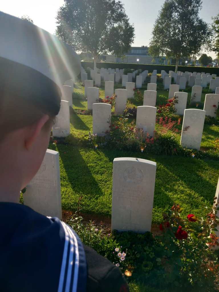 A Sea Cadet visits the grave of a family member who died in Normandy